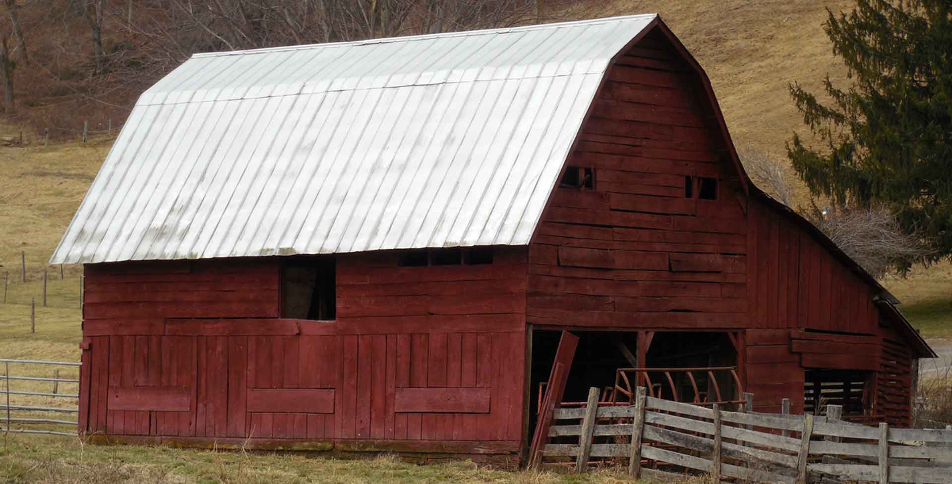 An old red barn with a metal roof.